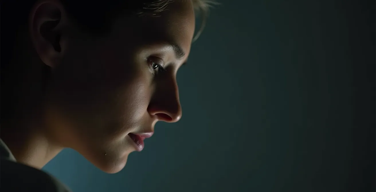 Visage en demi-profil avec jeu d'ombre et lumière, symbolisant le dialogue interne et la critique intérieure.